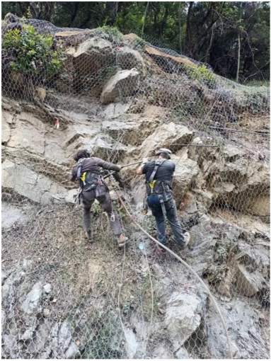 operai sistemano la rete armata in aderenza sulla roccia