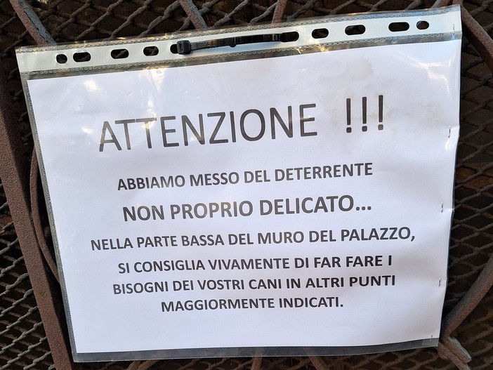 L’avviso intimidatorio in un portone, deterrente sul muro per non far urinare i cani