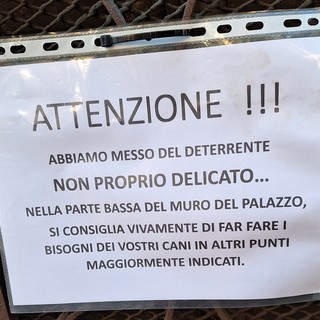 L’avviso intimidatorio in un portone, deterrente sul muro per non far urinare i cani